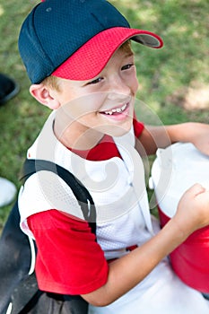 Little league baseball player happy after game.