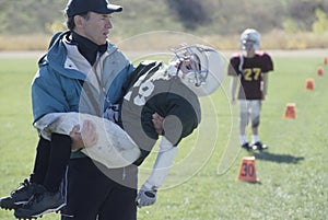 Little League coach with injured football player