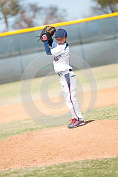 Little league pitcher starting his wind up.