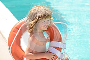 Little lifeguard. Summer kids holidays. Happy child playing with lifebuoy in the sea. Kids having fun on the beach.