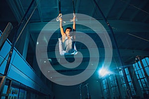 Little male gymnast training in gym, flexible and active