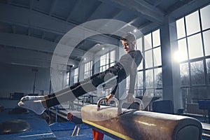 Little male gymnast training in gym, flexible and active