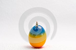 A little man is sitting on a Easter Egg