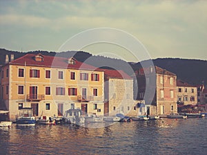 Little marina with moored boats and traditional architecture on Hvar island