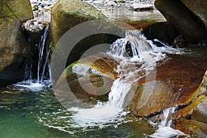 Little marvellous waterfall among the rocks of mountain creek