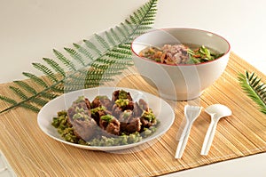 little meatballs with green chili sauce in a plate and gravy in a bowl