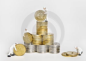 Little men in uniform build a tower of coins.