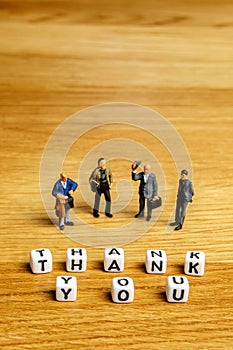 Little miniature figurines with little dices forming word thank you as a part of team meeting collection pictures