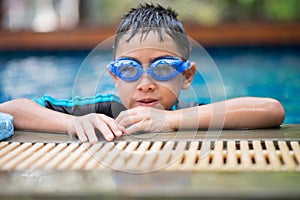 Little mix Asian Arab boy swimming at swimming pool outdoor activity