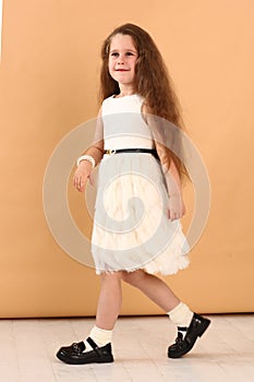 little model girl with long brown hair in designer white dress with belt, military boots full body photo walking.