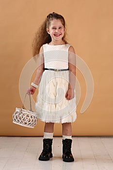 little model girl with long brown hair in designer white dress with belt, military boots full body photo walking.