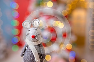 Little mouse toy, symbol of Chinese happy new 2020 in grey dress and new year decoration blur background. Horoscope sign 2020. New