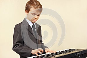 Little musician in suit playing the electronic synthesizer