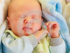 Little newborn baby sleeping calmly in blanket