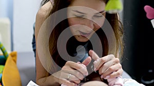 Little newborn girl lies in her crib with toys