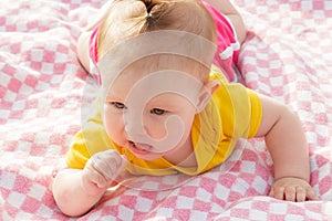 Little newborn girl lying on the grass