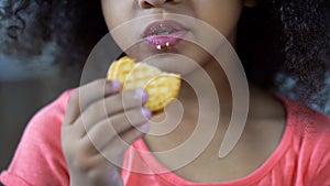 Little nice girl eating sweet cookie, lips cowered with crumbs, unhealthy food