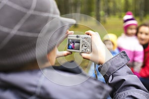 Little offspring shooting his family in park outside, lifestyle people concept