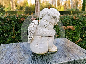 A little old angel on a tombstone in the cemetery