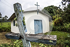 Little old chapel with wooden cross in coutryside