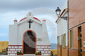 Little old christian chapel with old houses in front of the ocea