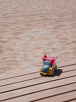 Little old toycar isolated on some planks with a sandy beach photo