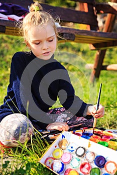 Little painter at work near waterfall