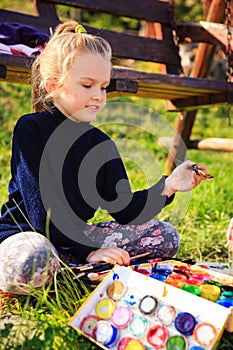 Little painter at work near waterfall