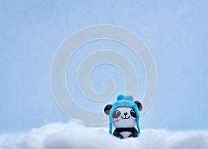 Little panda porcelain figurine in winter snow isolated on black background