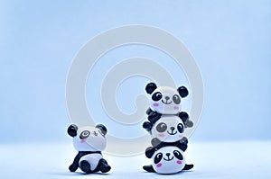 Little panda porcelain figurines isolated on black background