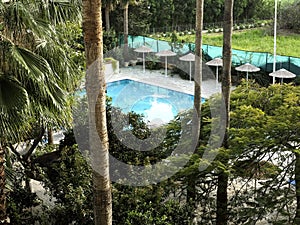 A little paradise. Top view of the courtyard garden of the resort hotel with a small pool surrounded by tropical plants
