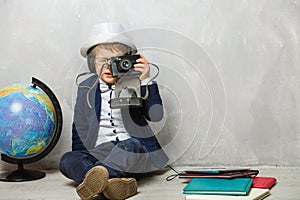 little photographer, boy with camera, stylishly dressed child in a waistcoat with a tie takes pictures on a digital
