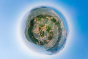 Little planet aerial view of Sorrento coast, Italy. Streets of city with hotels and restaurants are located on rocky seashore,