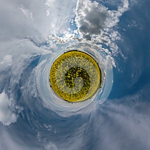Little planet with rapeseed flowers in blue sky with clouds  in spherical abstract aerial view. Curvature of space