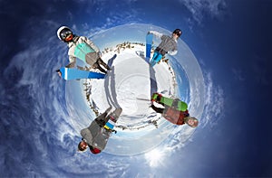 Little planet with snowboarders on blue sky backdrop