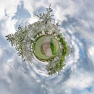 Little planet spherical panorama 360 degrees. Spherical aerial view  in blooming apple garden orchard with dandelions. Curvature