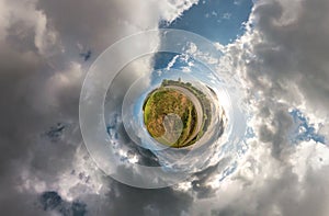 Little planet spherical panorama 360 degrees. Spherical aerial view in field in nice day with awesome clouds. Curvature of space.