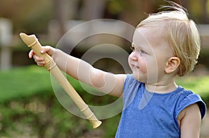 Little pointing girl in blue dress in park