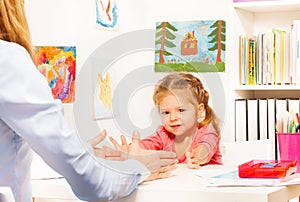 Little preschooler doing finger exercises at table