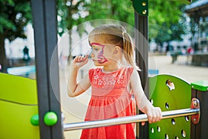 Little preschooler girl with butterfly face painting outdoors