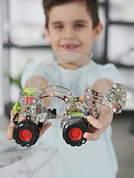 little preteen boy play with steel mechanical constructor set close up photo