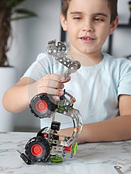 little preteen boy play with steel mechanical constructor set close up photo