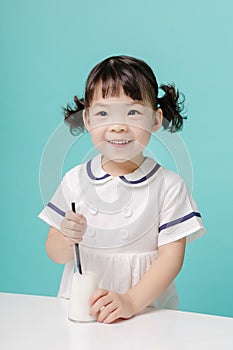 Little pretty Asian girl laughing portrait with milk and bread, healthy and happy lifestyle