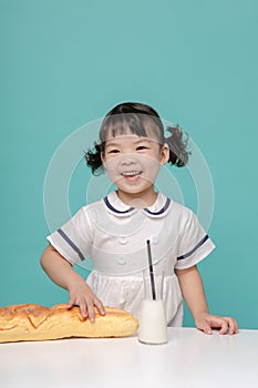 Little pretty Asian girl laughing portrait with milk and bread, healthy and happy lifestyle