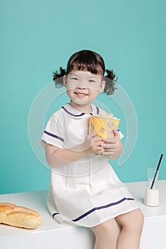 Little pretty Asian girl laughing portrait with milk and bread, healthy and happy lifestyle