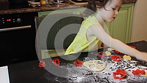 Little pretty child girl making Cinnamon Gingerbread Cookies. Christmas and New Year 2019 concept. red plastic forms, yellow dress