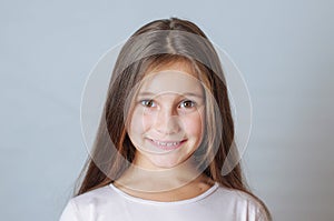 Little pretty girl age 6-7 years with very long hair expresses emotional joy and a smile on a white background