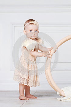 Little pretty girl with blue eyes  stands on a floor with flowers of a jasmine