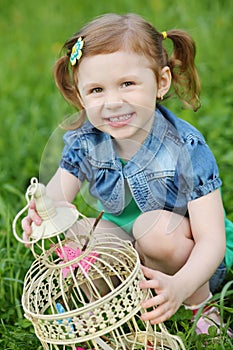 Little pretty girl holds coop with butterflies and photo