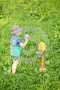 Little pretty girl plays mini basketball at green